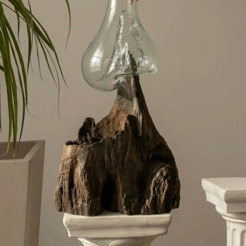 Pieza de vidrio soplado sobre madera, atravesada por la luz.