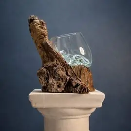 Pieza de vidrio reciclado sobre una raíz de eucalipto.